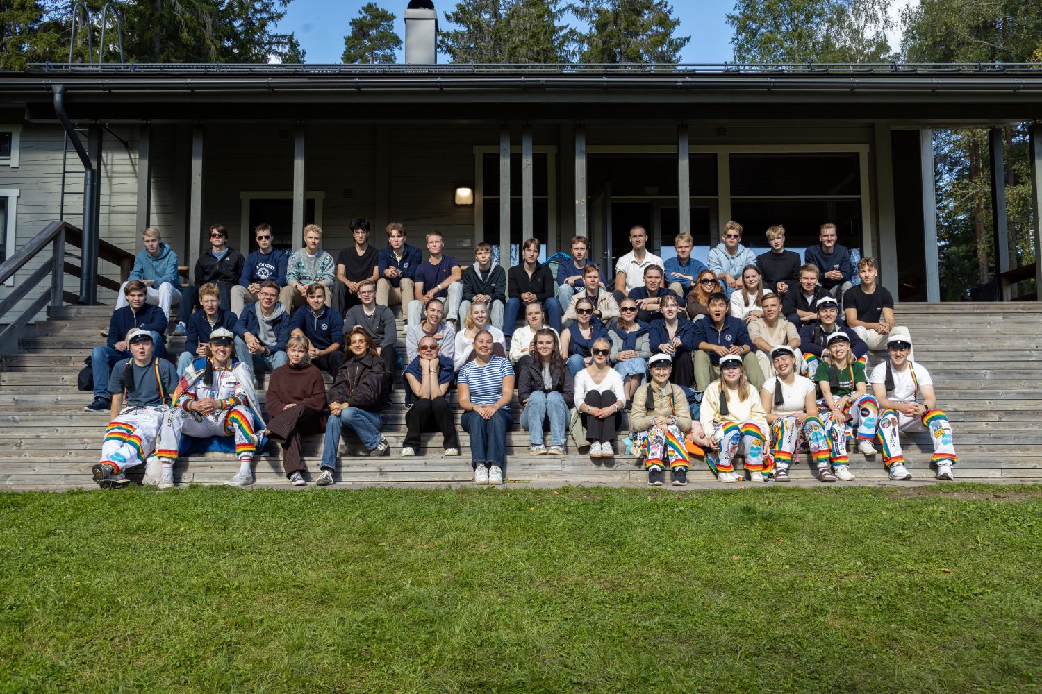 Fuksis in a group photo on the steps of a cabin