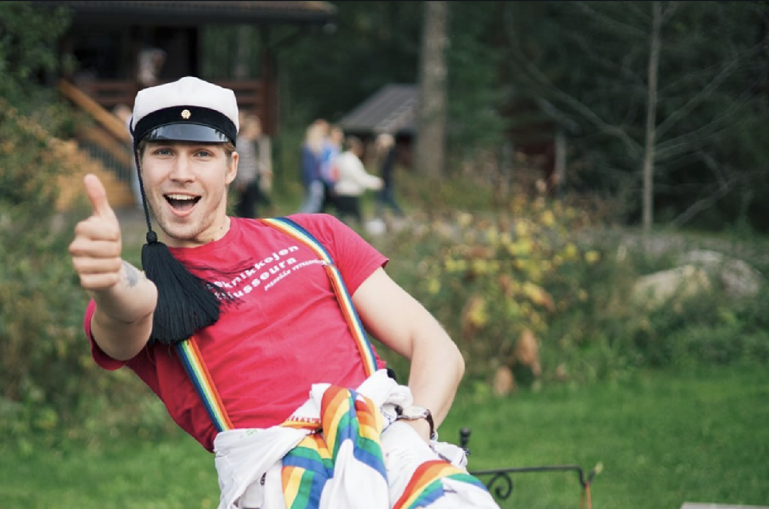 A teekkari in cap and overalls giving a thumbs up